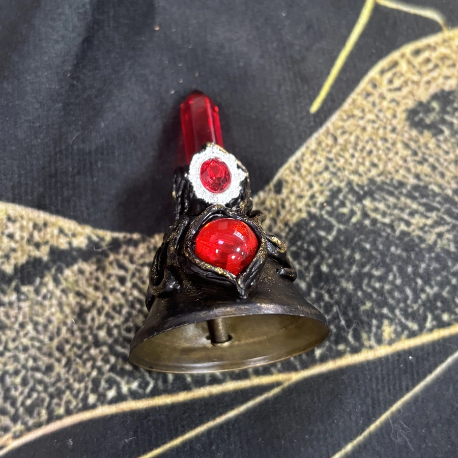 Handmade red crystal witch bell shown from the front with red stones and antique gold details