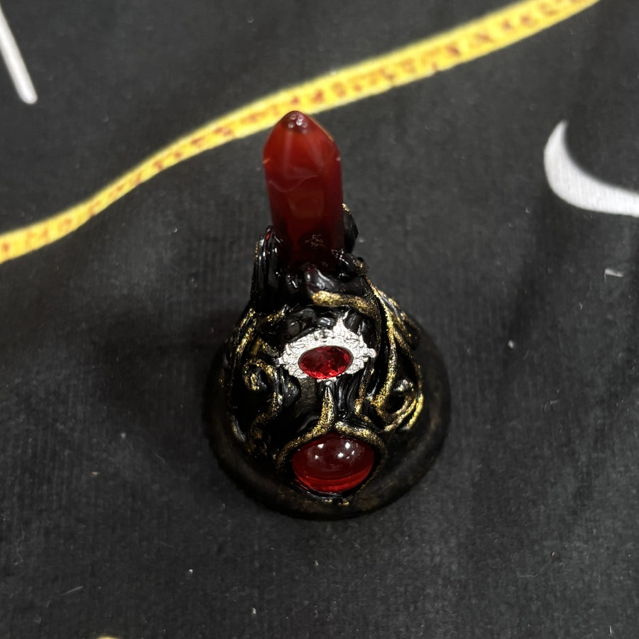 Front detail of a gothic red crystal bell with a black sculpted body and gold highlights