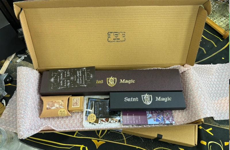 An existing SaintMagic wand arranged in premium gift packaging with ribbon and small surprises